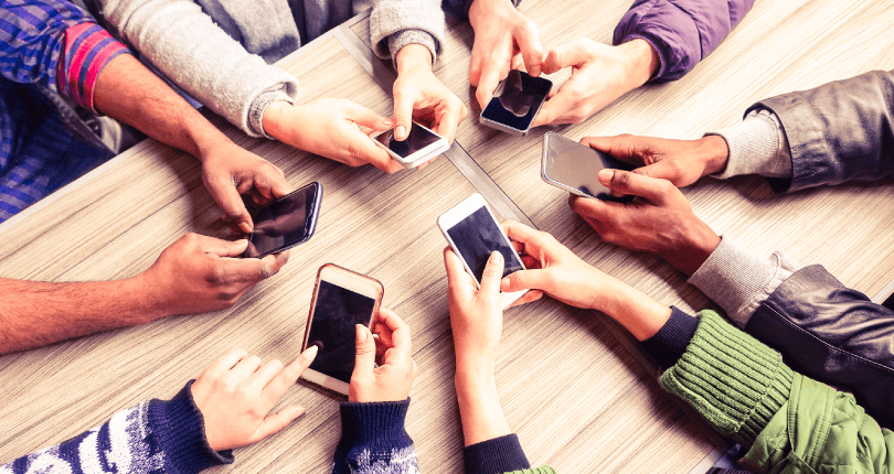 hands circle using phone in cafe 810x430 Blog popup | What's up with WhatsApp?