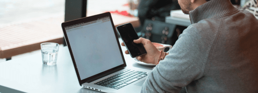 man in grey jumper checking his online payslip