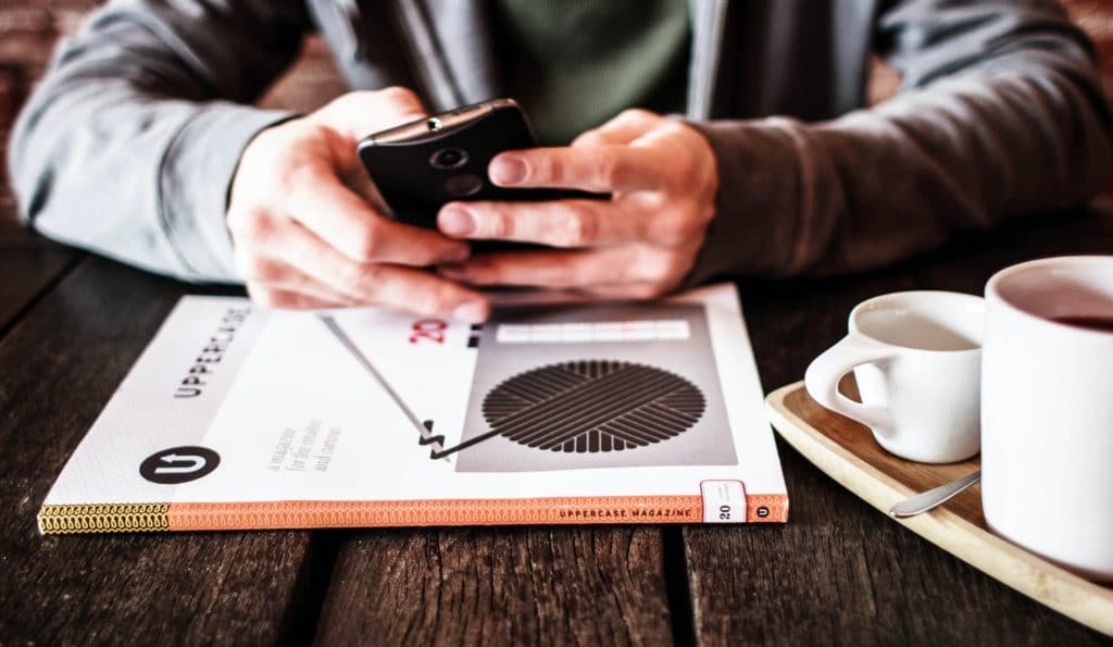 person checking their online payslip in a coffee shop