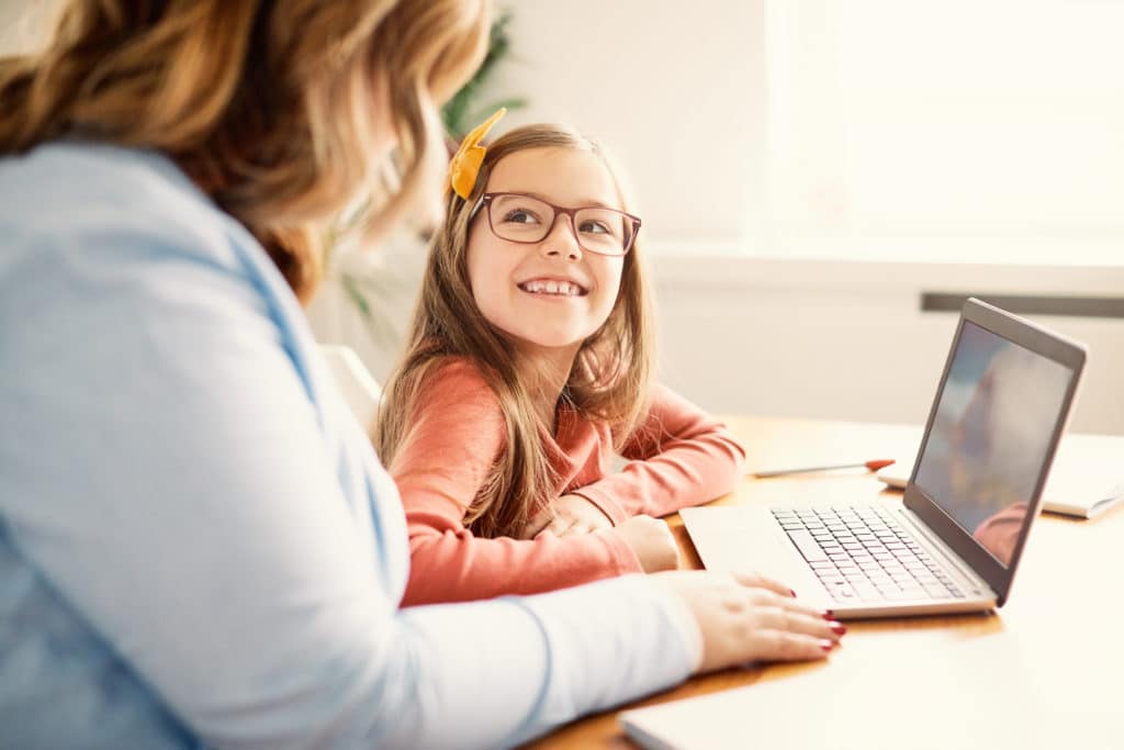 mother and daughter having fun checking laptop at home