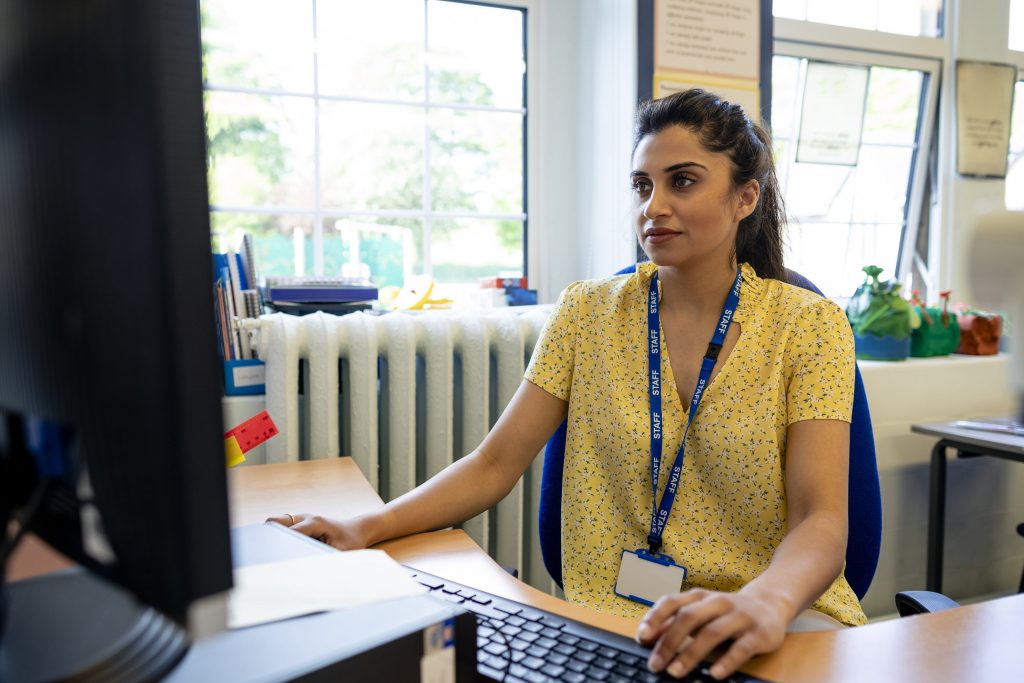 Trust staff member using IRIS Invoice Matcher on her desktop PC to improve trust-wide invoice management.