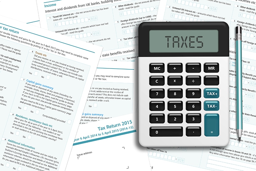 Calculating corporation tax - Image of calculator with Taxes on the screen and HMRC documents