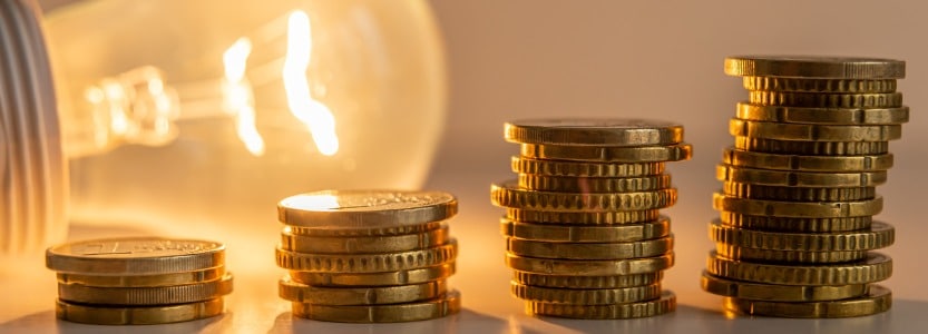 lit light bulb with coins beside it energy tariffs picture id1328805329 | UK businesses given temporary emergency energy price cap