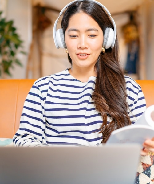 Person wearing headphones on laptop