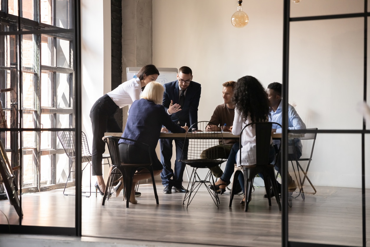 Large business team engaged in discussion in modern boardroom