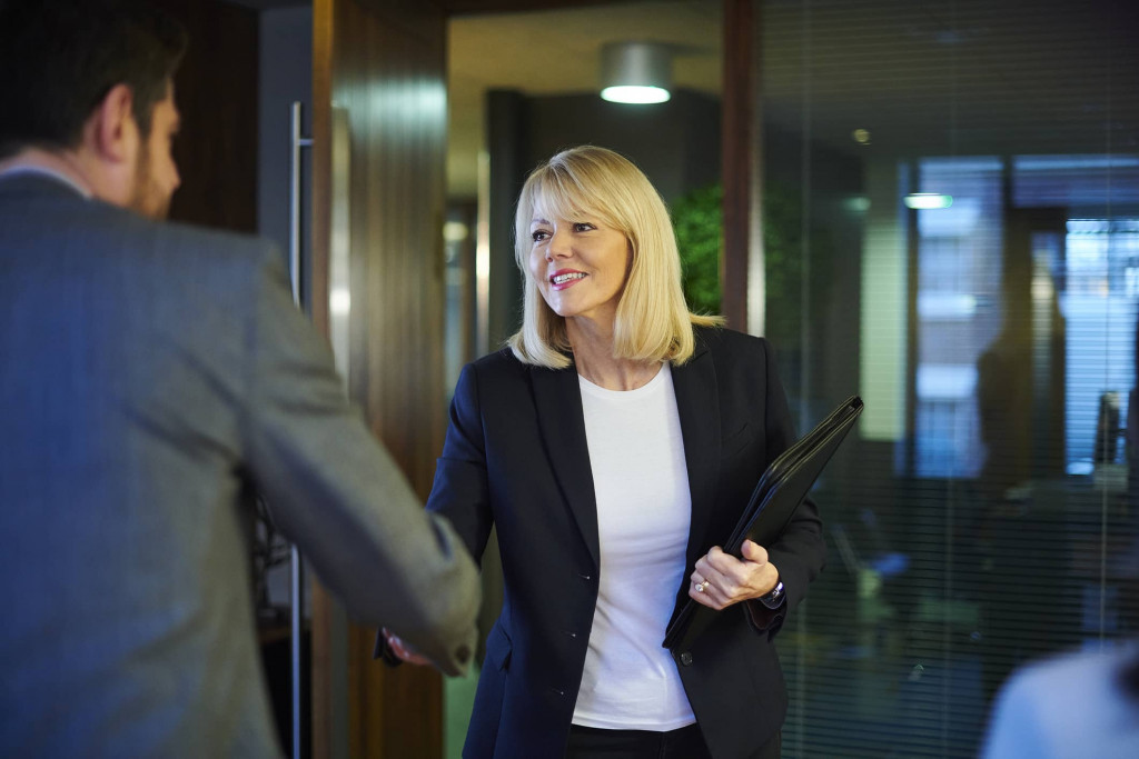 Woman shaking mans hand before meeting