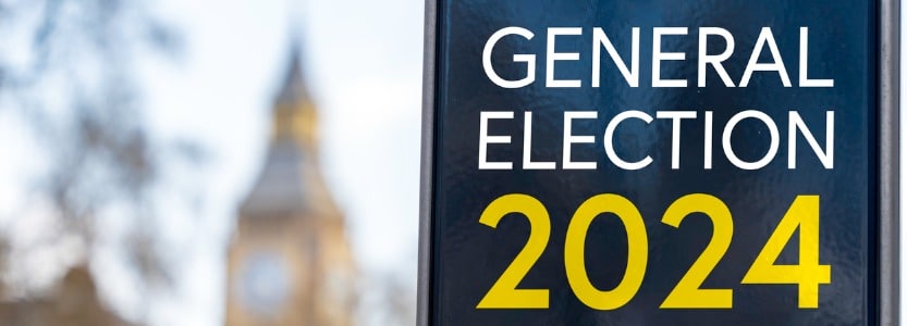 A sign that says General Election 2024, with House of Commons in the background