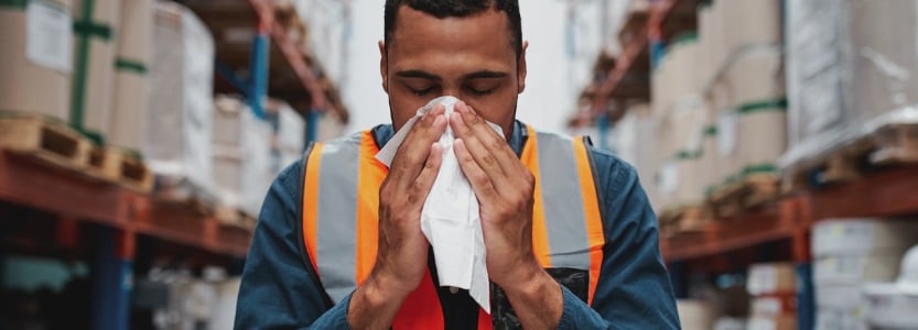 young sick african warehouse worker blowing nose while working wearing safety vest.jpg s1024x1024wisk20cPjH3R9SnZkIWUQx0eNPbQcMB9ryETalU86utM yZiIQ | Can staff work while signed off sick?