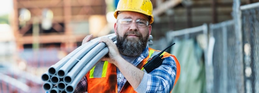 construction worker carrying pipes on | What is IR35? Understanding the rules