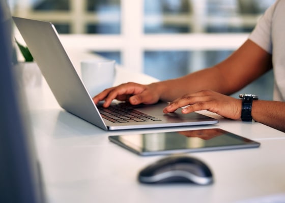 Hands typing on laptop