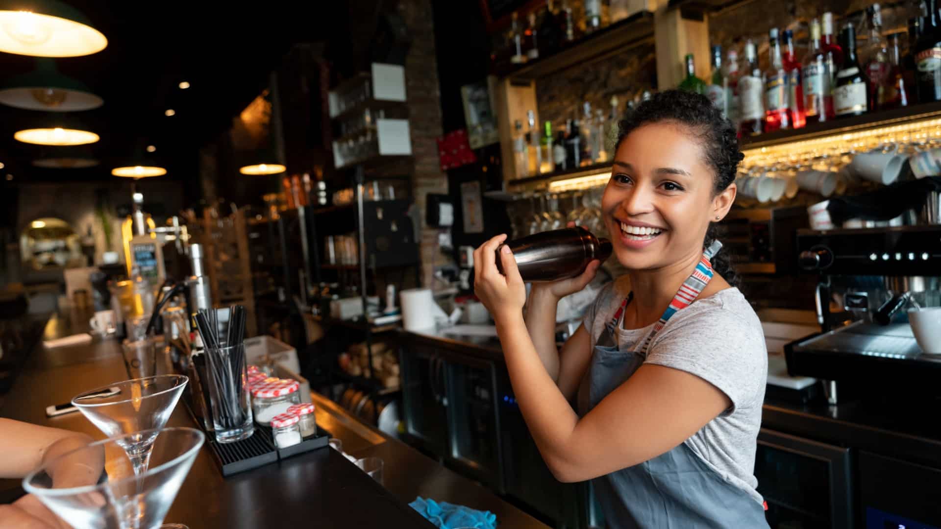 happy bartender mixing drinks at the | Three tips for managing rota demands in hospitality